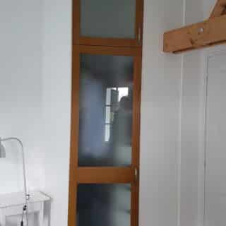 dressing d'angle avec corps laqué blanc et portes avec cadre en chêne et verres dépolis